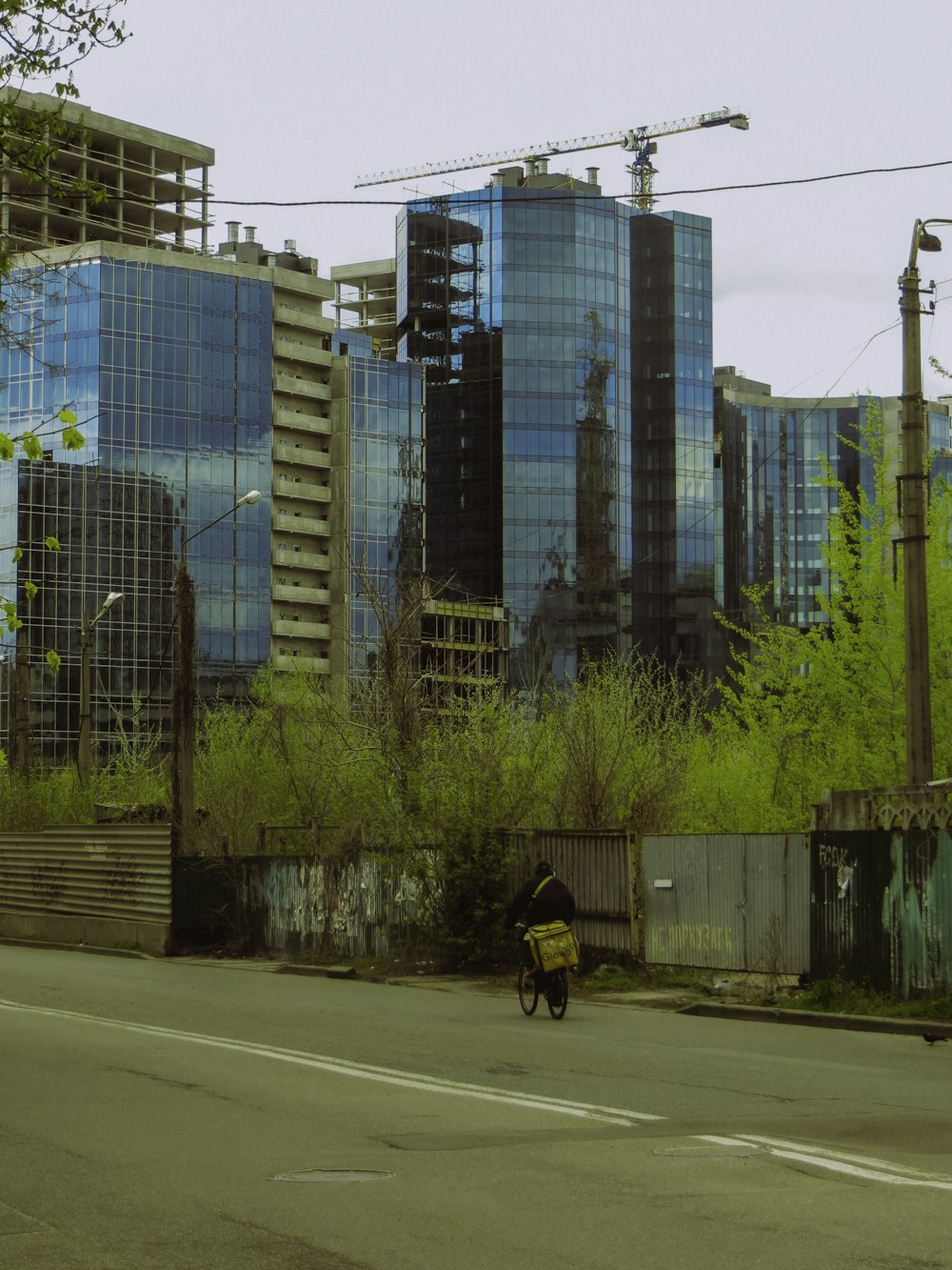 a man riding a bike down a street next to tall buildings