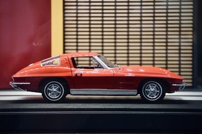 A sleek custom display case showcasing a vibrant Hot Wheels car in bright red.