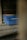 A set of blue plastic crates with the label 'INDUVECA 2' is placed in a dimly lit, rustic environment. The wooden walls and surfaces have a weathered appearance, adding to the rustic feel.