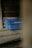 A set of blue plastic crates with the label 'INDUVECA 2' is placed in a dimly lit, rustic environment. The wooden walls and surfaces have a weathered appearance, adding to the rustic feel.