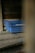 A set of blue plastic crates with the label 'INDUVECA 2' is placed in a dimly lit, rustic environment. The wooden walls and surfaces have a weathered appearance, adding to the rustic feel.
