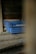 A set of blue plastic crates with the label 'INDUVECA 2' is placed in a dimly lit, rustic environment. The wooden walls and surfaces have a weathered appearance, adding to the rustic feel.