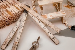 Blueprints and construction tools spread out on a wooden table.