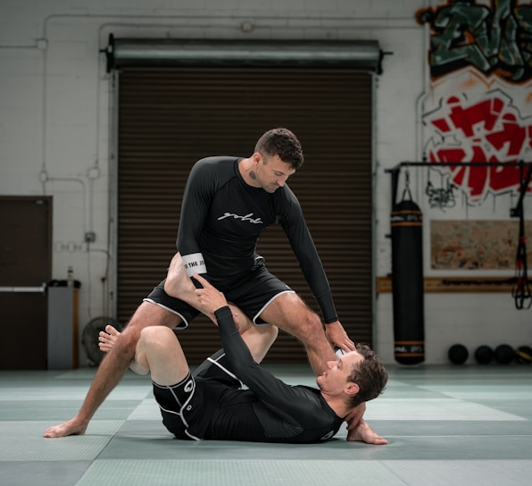 a couple of men standing on top of each other in a gym