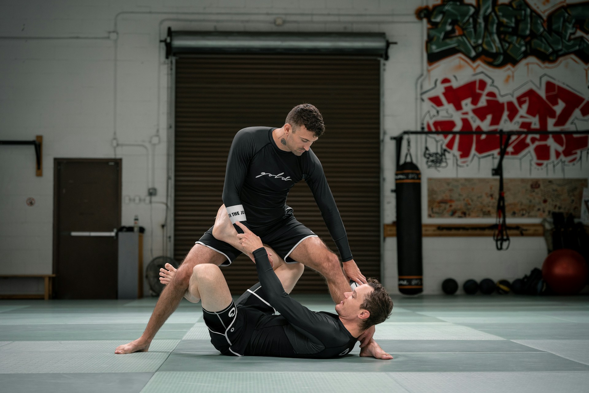 a couple of men standing on top of each other in a gym