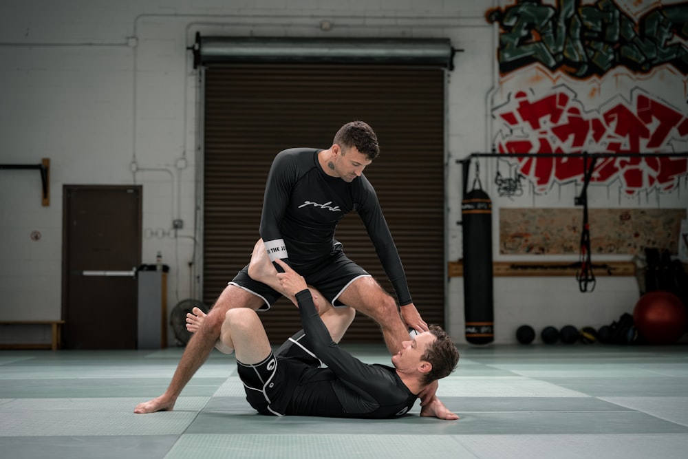 a couple of men standing on top of each other in a gym