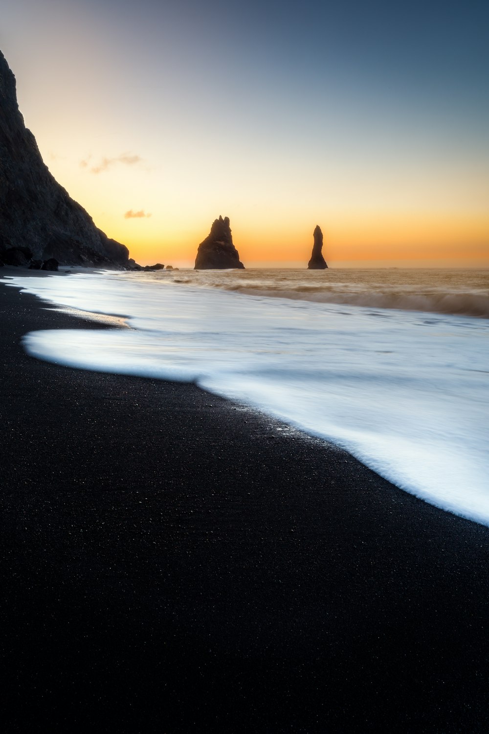 the sun is setting over the ocean and the beach