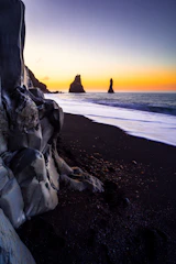 A serene black sand beach at dawn, symbolizing calm and steady focus.