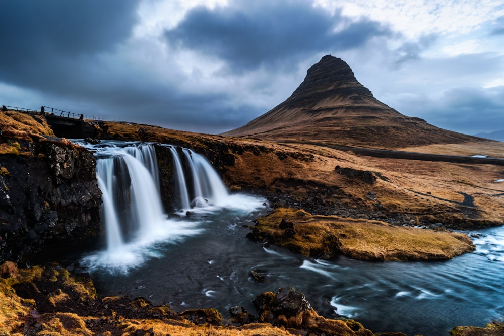 a waterfall with a mountain in the background