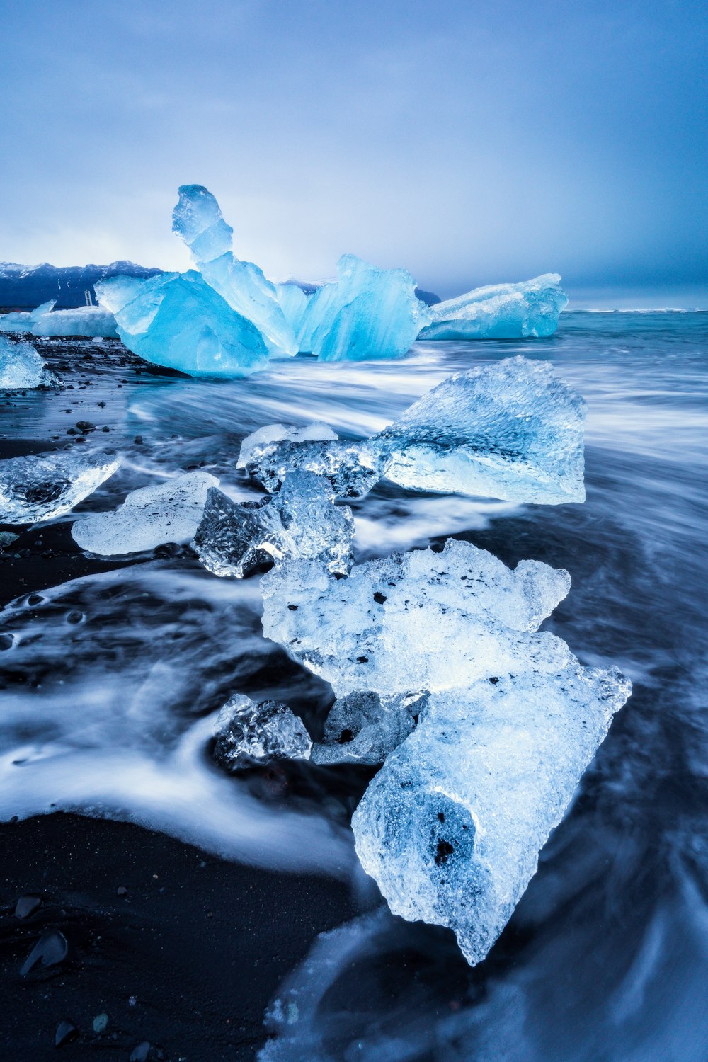 a group of icebergs floating on top of a body of water