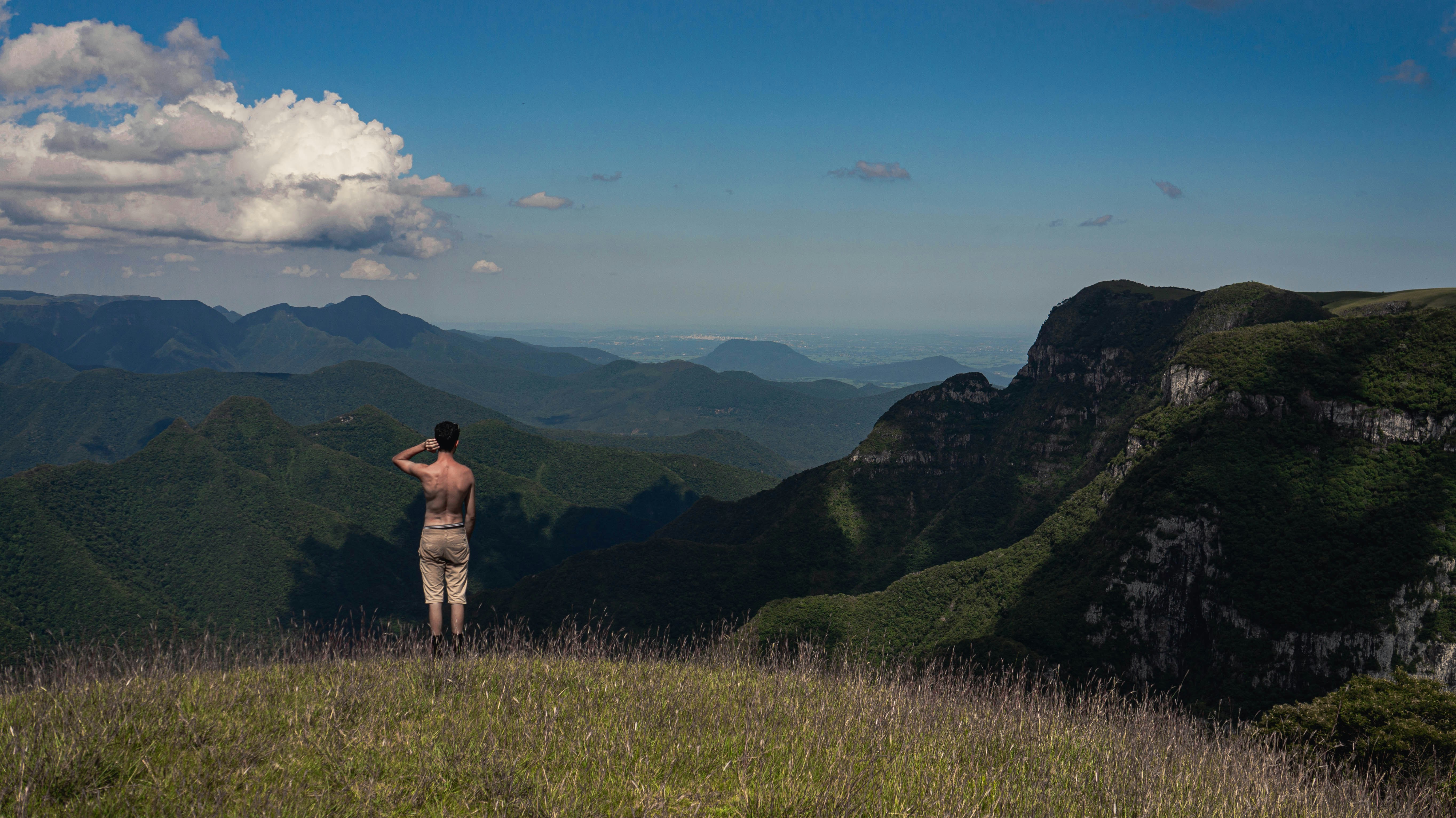 a man standing on top of a lush green hillside