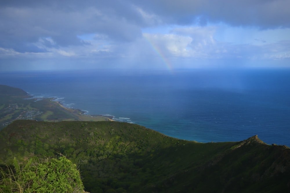 a rainbow shines in the sky over the ocean