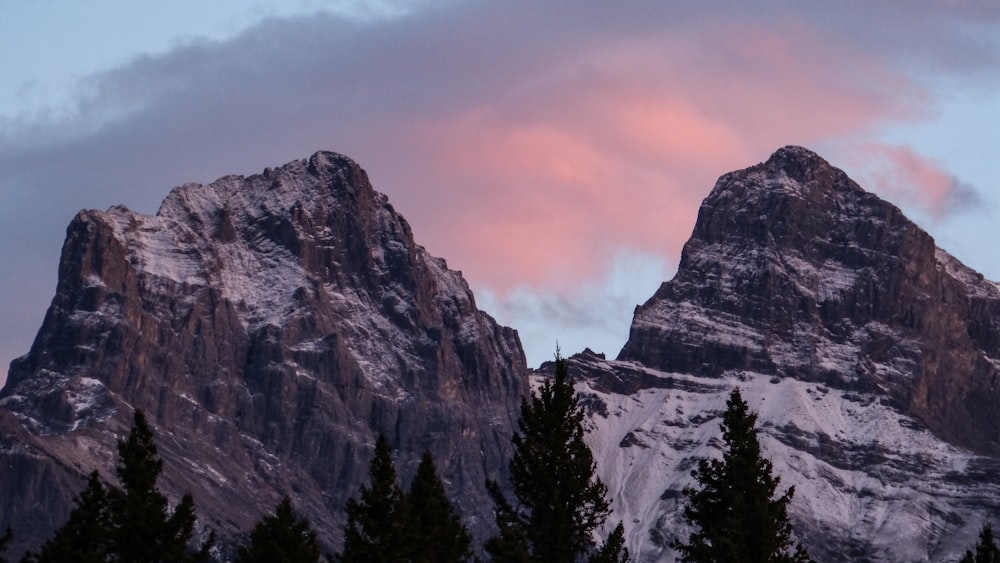 a snow covered mountain with a pink sky in the background