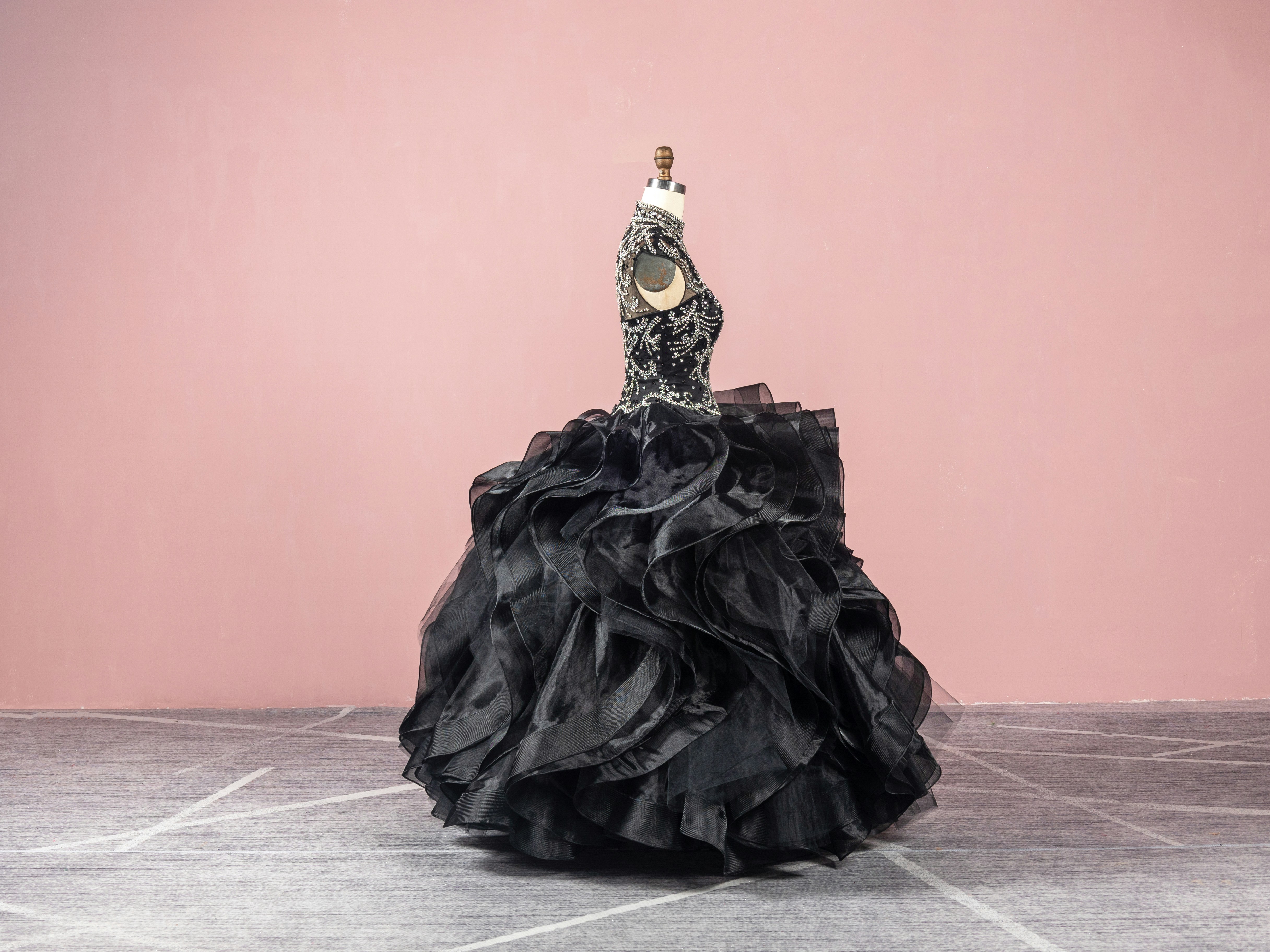 a woman in a black dress standing on a floor