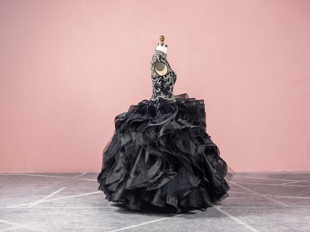 a woman in a black dress standing on a floor