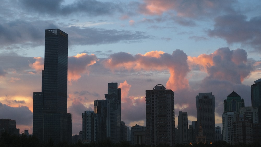 a view of a city at sunset with clouds in the sky