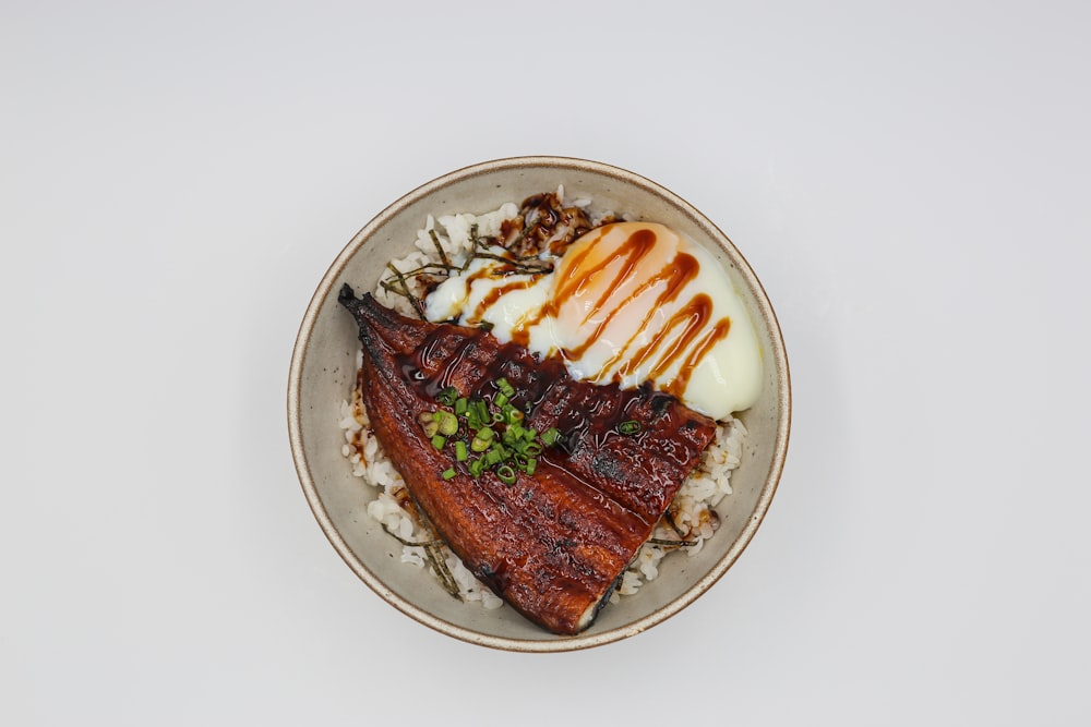 a white plate topped with meat and rice