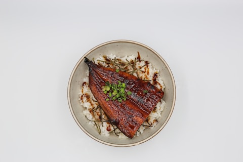a white plate topped with meat and rice