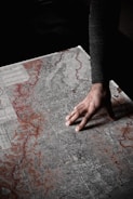 a person reaching for a piece of paper on a table