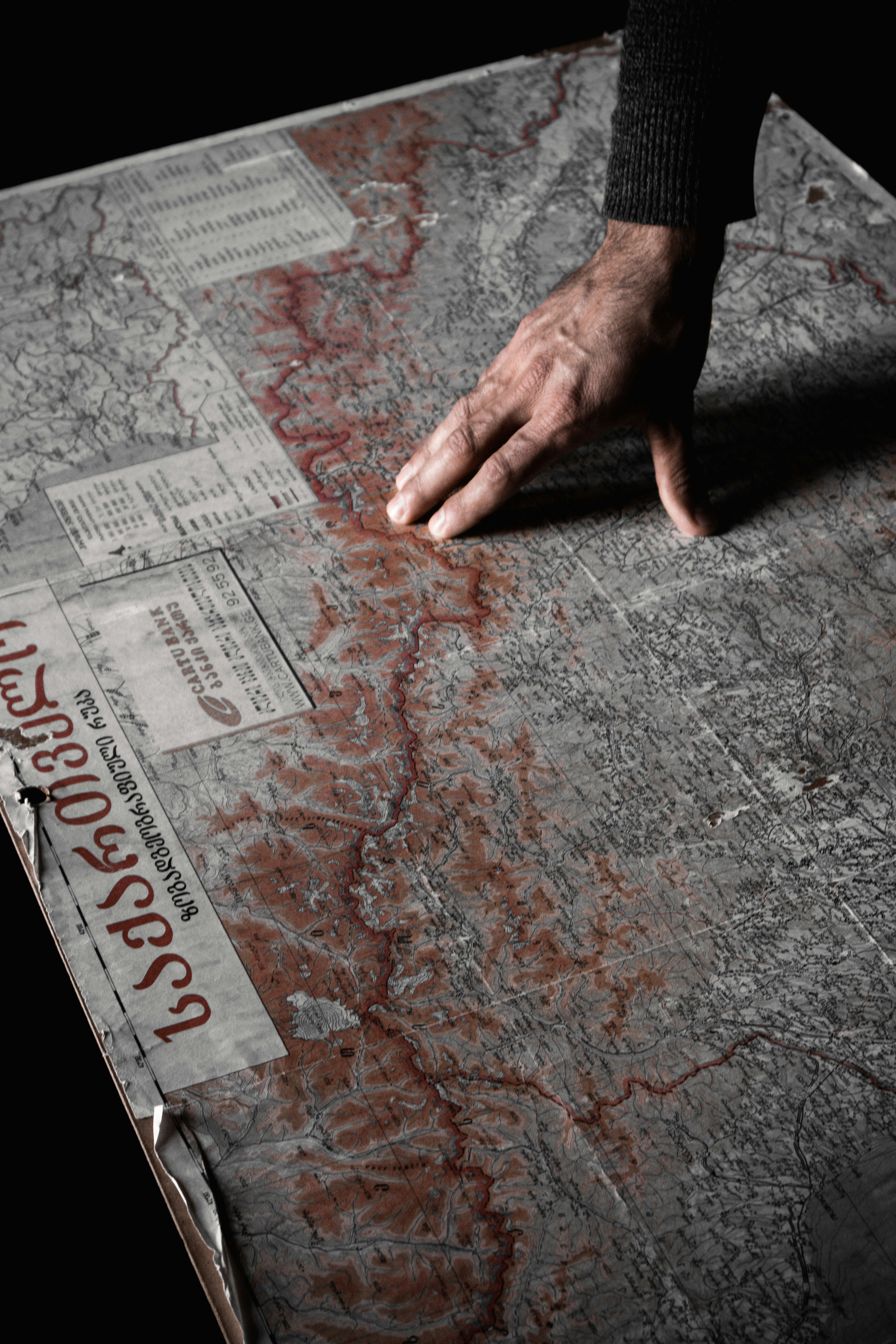 a person's hand on top of a newspaper