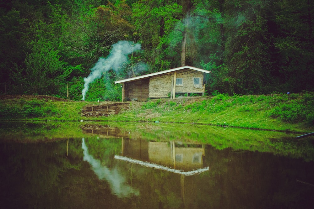 a small cabin sitting next to a body of water