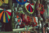A vibrant display of colorful knitted gloves hanging on a rustic market stall.