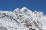 a large mountain covered in snow under a blue sky