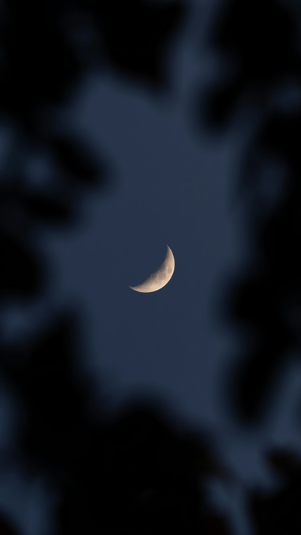 a half moon is seen through the clouds