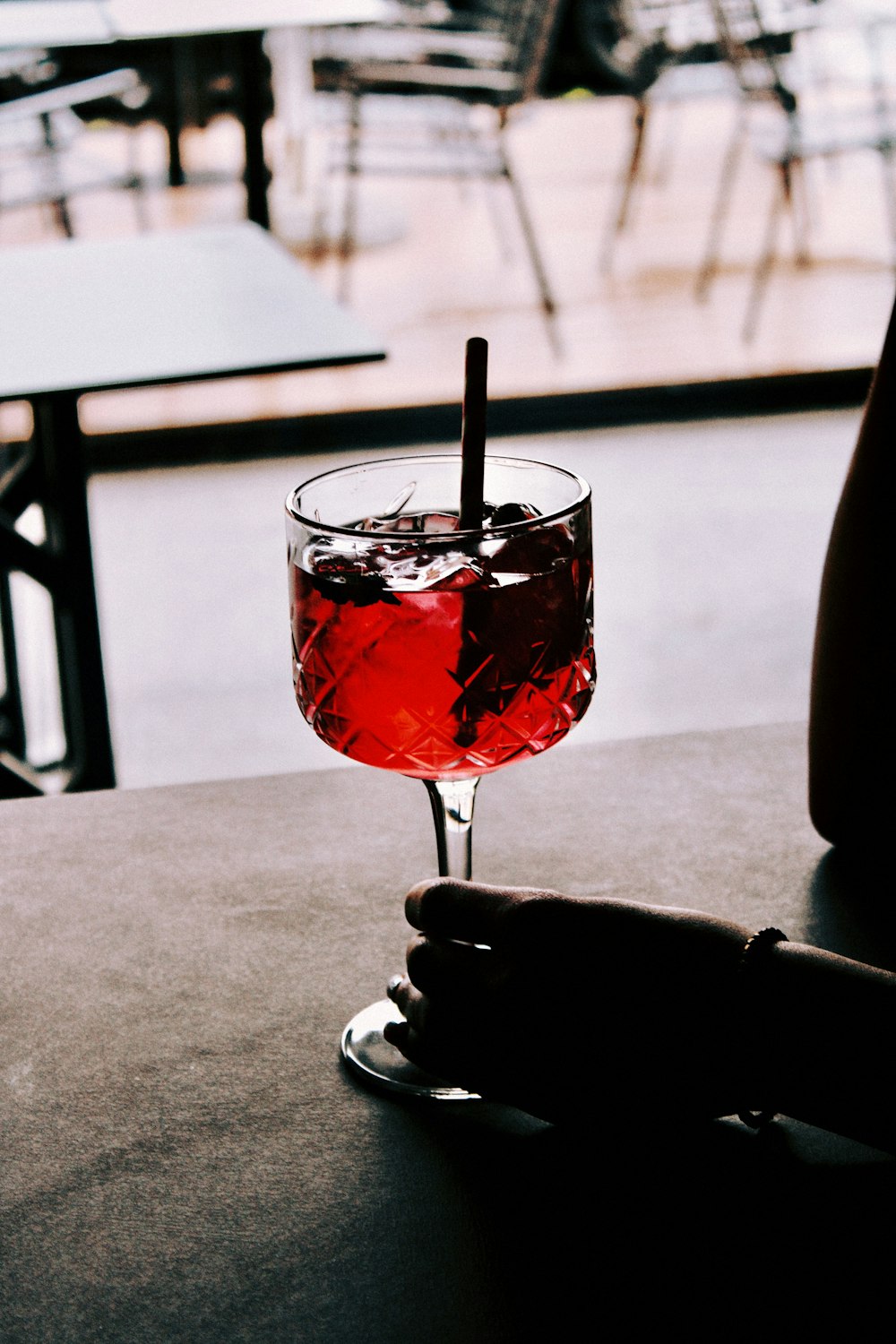 a person holding a wine glass with a drink in it