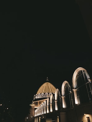 Nighttime exterior shot showcasing the illuminated architectural details.