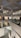 A modern art gallery with multiple levels and open spaces, featuring various artworks on the walls. The structure is illuminated by soft indoor lighting, highlighting paintings and photographs. The gallery features glass railings and a spacious, geometric design.