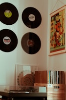 A cozy listening nook with vintage posters and a record player surrounded by crates of vinyl.