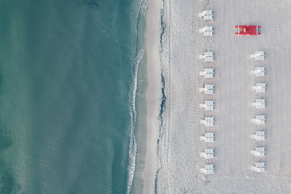 an aerial view of a beach with chairs and umbrellas