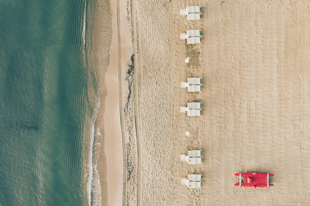 an aerial view of a beach with chairs and umbrellas