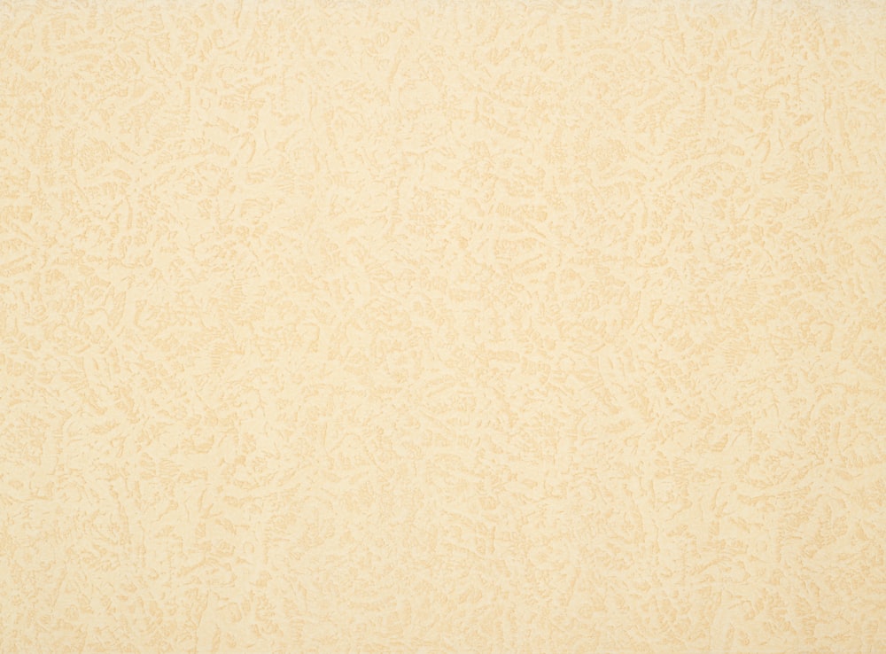 a beige background with a pattern of leaves