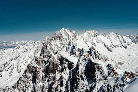 A breathtaking high-resolution photo of a towering ice mountain under a clear blue sky, showcasing intricate ice formations.
