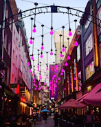 Street evangelism team engaging warmly with passersby under purple evening lights.