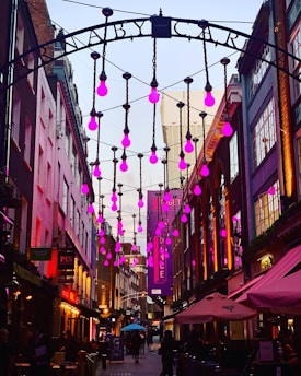 A vibrant Medellín street scene with young musicians playing under purple lights.