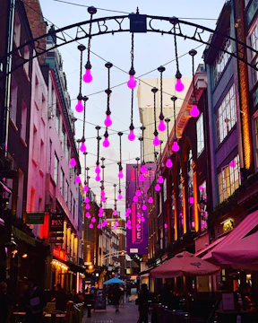 Street evangelism team engaging warmly with passersby under purple evening lights.