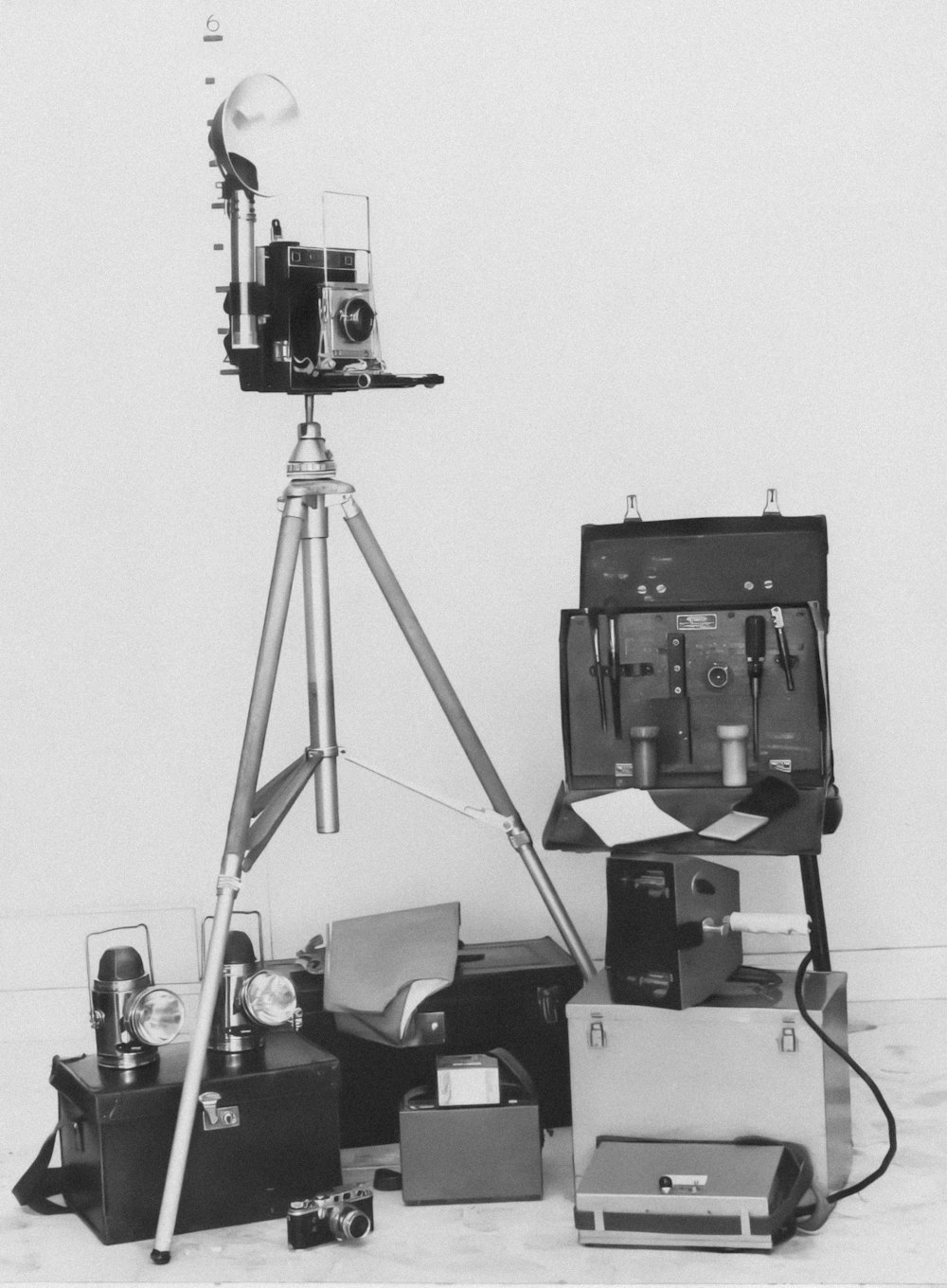 a black and white photo of a camera on a tripod