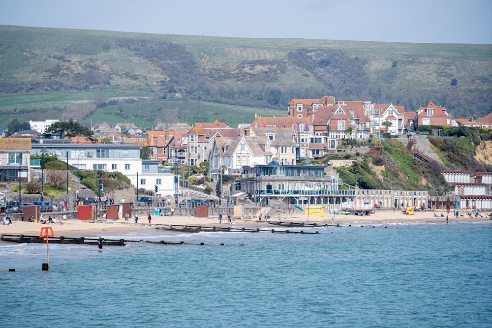 a view of a beach with houses on a hill in the background