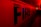 Large capital letters spelling 'FIRE' are prominently featured against a red backdrop. The scene is illuminated with intense red and yellow lighting, creating a dramatic and urgent atmosphere. The setting appears to be indoors, possibly a hallway or tunnel.