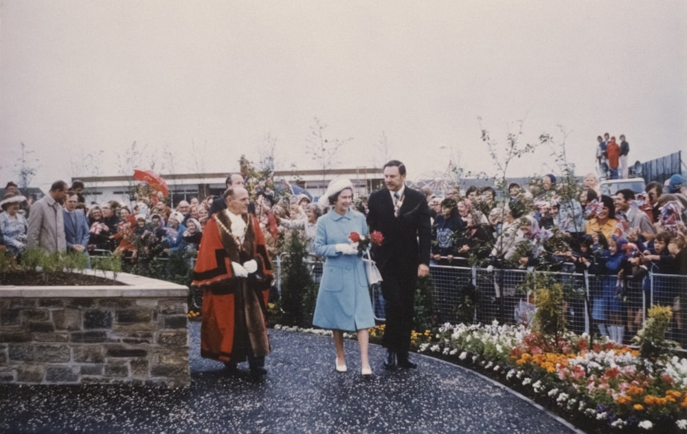 a man and a woman are walking in front of a crowd