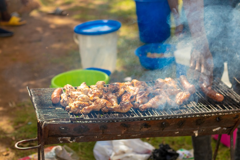 a person is cooking chicken on a grill