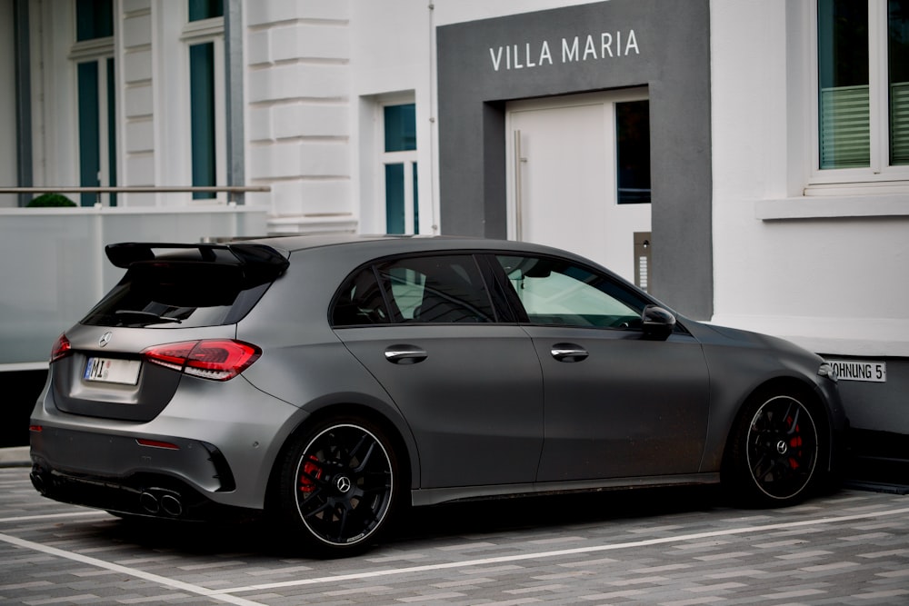 a grey car parked in front of a building