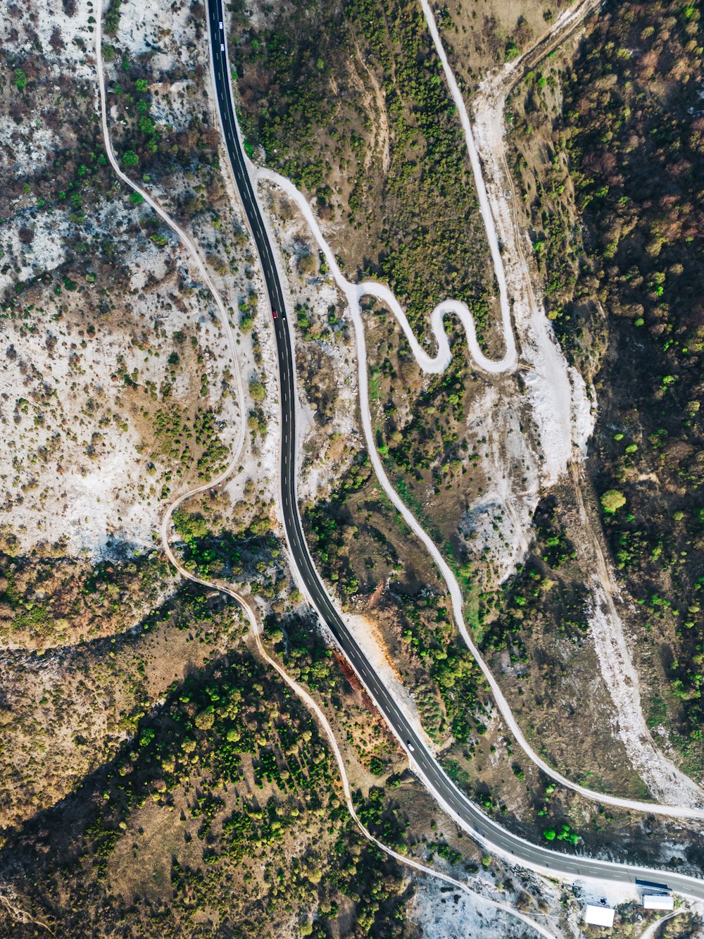 an aerial view of a winding road in the mountains