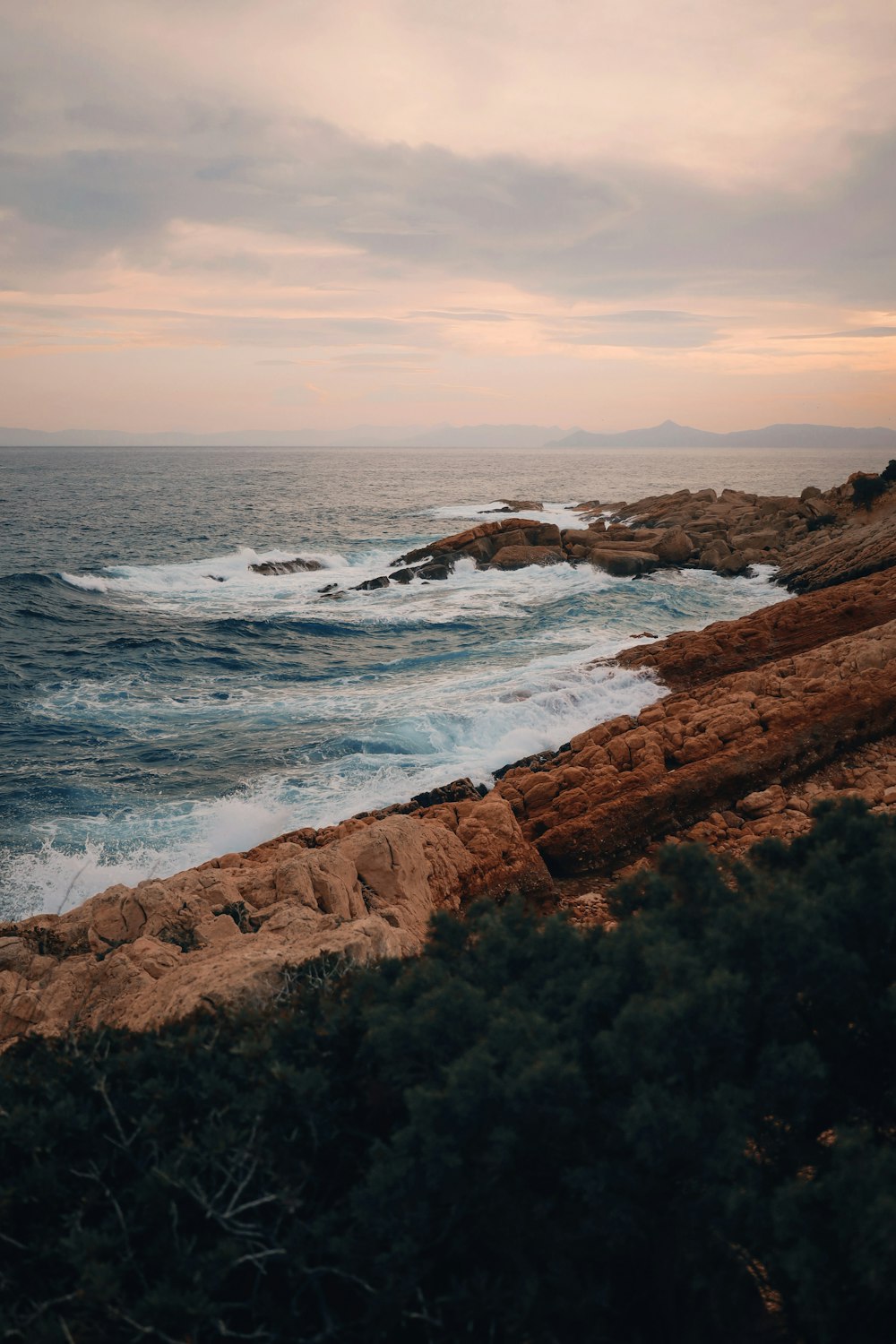 a view of the ocean from a rocky shore