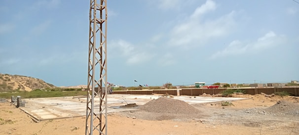 A construction site showing workers laying foundation for a new home under a clear sky.