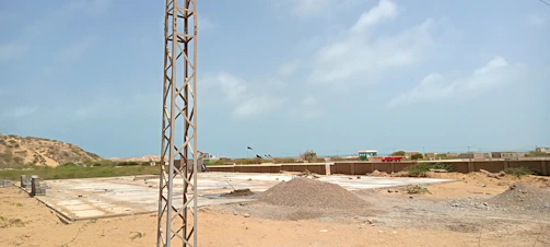 A professional construction site with continuous flight auger piles being installed under a clear sky.