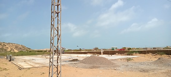 A construction site showing workers laying strong concrete foundations under a clear blue sky.